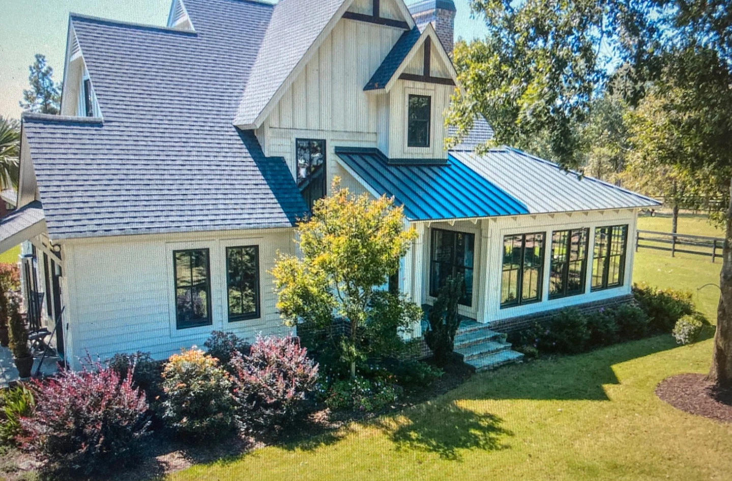 An angled view of the Aiken home's layered gables, white siding and landscaped garden